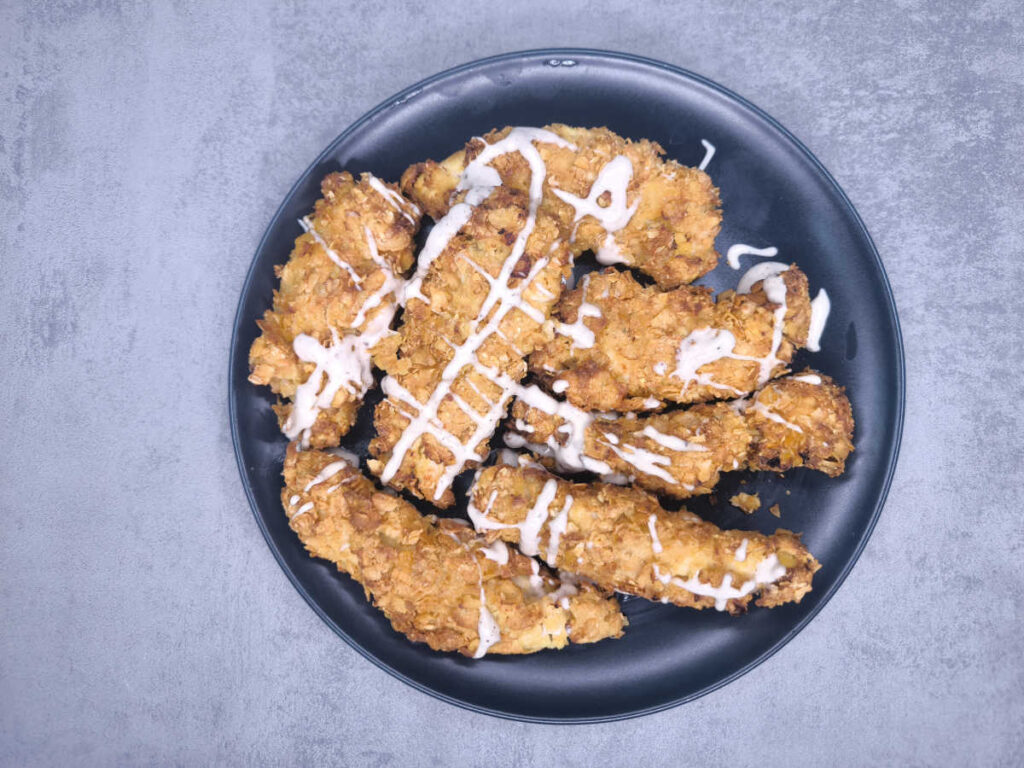 pollo fritto in friggitrice ad aria guarnito con salsa e impiattato