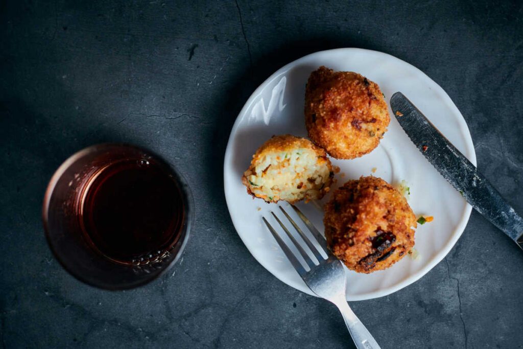 polpette di tonno e uova con bicchiere di vino rosso accanto