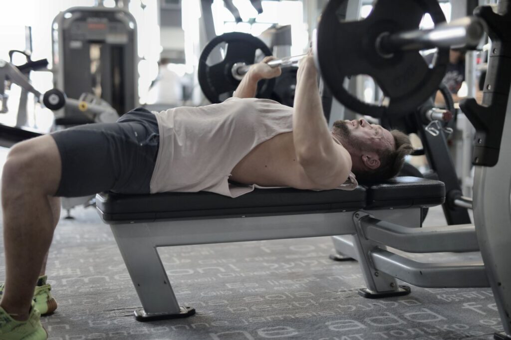 Uomo che fa panca piana in palestra